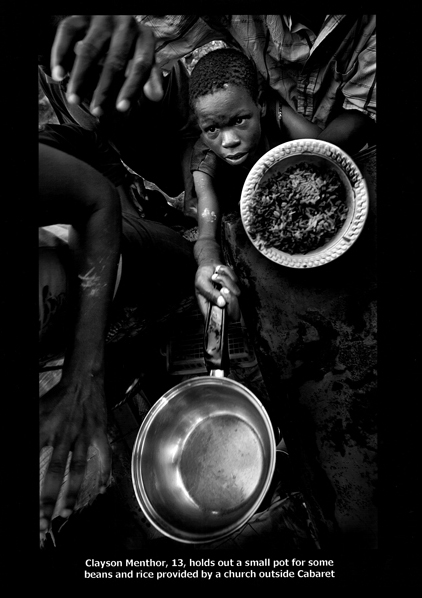 Clayson Menthor, 13, holds out a small pot for some beans and rice provided by a church outside Cabaret. (Photo Credit: Patrick Farrel, The Miami Herald, September 10, 2008 via the Pulitzer Prize website)